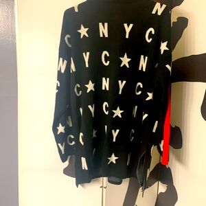 Black sweater with white letters and red trim down each sleeve